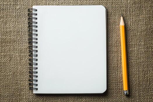 A pencil and a notebook with a blank page photo
