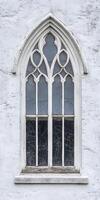 A window with a white frame and a blue stained glass window photo