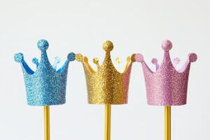Colorful Glitter Crowns on Sticks Against White Background for Celebrations and Parties photo
