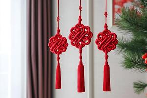 Three red Chinese ornaments hanging from a tree photo