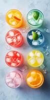 A row of colorful drinks with ice cubes and limes photo