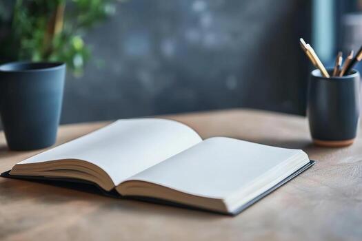 A book is open on a table with a pencil and a cup photo