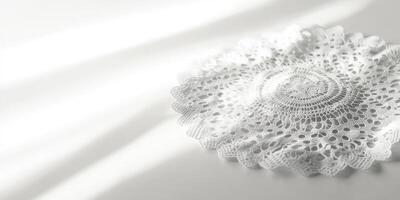 A white lace doily sits on a white table photo