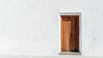 A wooden door with a white frame sits in front of a white wall photo
