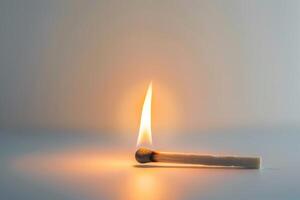 A match is lit and the flame is on the side of the match photo