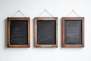 Three wooden frames with black chalkboards hanging from them photo