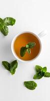 A cup of tea with a sprig of mint on top photo