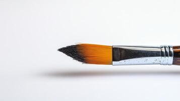 Detailed image of a paintbrush with vibrant orange bristles, perfect for art, creativity, and design themes. photo