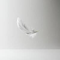 A white feather is floating in the air. The feather is light and delicate, and it seems to be floating effortlessly photo
