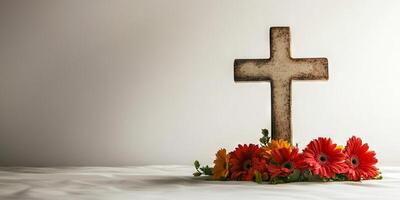 A cross is on a table with flowers. The cross is old and the flowers are red. Concept of reverence and spirituality photo