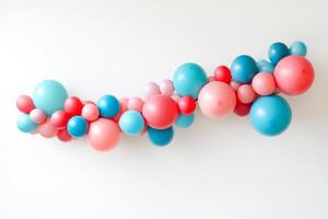 Vibrant balloon garland in shades of blue, pink, and red on a white background, perfect for festive occasions and party decorations. photo