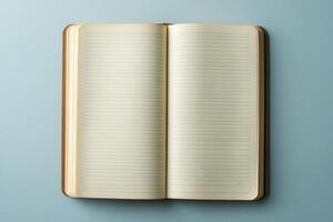 A book is open to a blank page. The book is on a blue surface photo