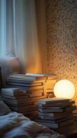 A serene bedroom corner featuring piles of books and a glowing lamp, creating a cozy and inviting reading atmosphere. photo