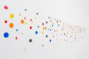A long line of colorful dots hanging from the ceiling. The dots are in various colors and sizes photo