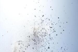 A cloud of dust is in the air. The dust is white and gray. The sky is blue photo