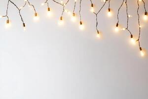 A string of lights is hanging from the ceiling. The lights are on and are evenly spaced. The lights are on a white background photo