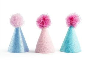 Three party hats with pom poms on top. One is blue, one is pink, and one is blue and pink photo