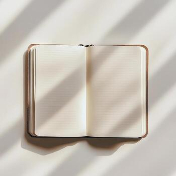 A book is open to a blank page. The book is on a white surface photo
