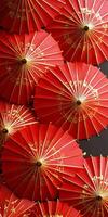 Close up of traditional red Japanese paper umbrellas with intricate gold designs, showcasing cultural artistry and vibrant colors. photo