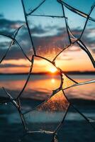 Stunning Sunset Through Broken Glass with Vibrant Colors and Dramatic Sky Over Serene Lake photo