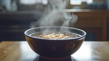 A steaming bowl of soup sits on a rustic wooden table, emitting warm steam. The inviting atmosphere suggests comfort and culinary delight, perfect for meal enjoyment. photo