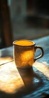 A rustic ceramic mug bathed in warm sunlight on a wooden table, creating a cozy and inviting atmosphere. photo