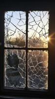 Broken Window Pane with Sunlight Streaming Through Cracks at Sunset in a Rustic Setting photo