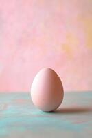 Pastel-Colored Egg on Soft Textured Surface with Blurred Background in Gentle Pink and Blue Tones photo