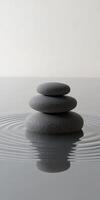 Zen Stones Balancing on Water Surface Creating Ripples in a Minimalist and Serene Environment photo