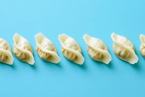 Fresh Dumplings Arranged Neatly on a Vibrant Blue Background photo