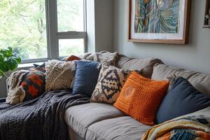 A couch with a variety of pillows on it. The pillows are of different colors and sizes photo