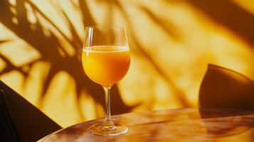 Bright Citrus Beverage in Glass with Shadow Patterns on Wall photo