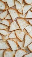 Freshly Sliced Bread Pieces Spread Across a White Surface photo