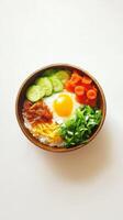 Colorful Bibimbap Bowl with Egg and Fresh Vegetables on White Background photo