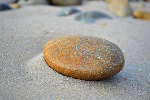 Smooth Round Stone on Sandy Beach Surface Under Soft Natural Light photo