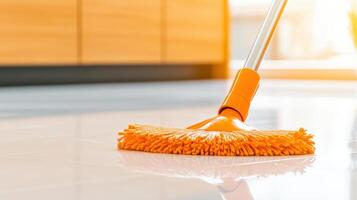Man mopping the kitchen floor in a modern home with sunlight enhancing the sleek design and wooden elements photo