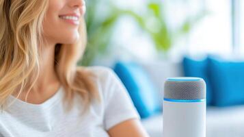 Modern living room where a woman sets comfortable temperature using voice commands to a smart speaker during the day photo