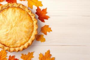 Thanksgiving pie surrounded by autumn leaves on a wooden surface for festive holiday gatherings photo