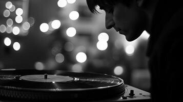 A man is playing a turntable in front of a black and white photo