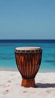 A drum sitting on a beach with the ocean in the background photo