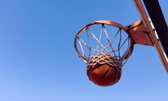 Basketball scoring a basket as it goes through the hoop and making a swish in the net photo
