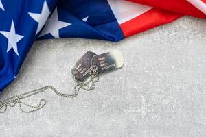 America United States flag and chain dog tags, military symbolizing, studio shot on concrete board background, US Veterans or Independence day concept photo