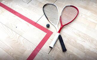 Squash rackets and ball on court floor, top view photo