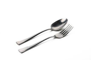 Elegant silver utensils quietly resting on a white surface in soft natural light photo