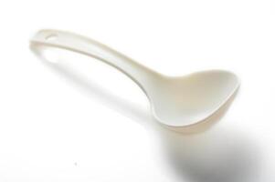 Creative use of a white plastic ladle, captured in a minimalist style against a soft background photo