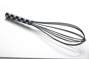 Whisk resting on a smooth surface awaiting the start of a culinary adventure in a bright kitchen photo