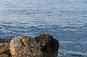 Serene waterside view with beautiful rocky formations at dawn's gentle light photo