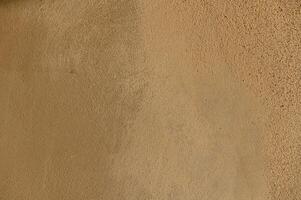Texture of warm earth tones on a sunlit wall evokes a sense of calm and natural simplicity photo