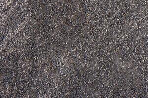 Textured surface of gravel creating a rough backdrop for artistic exploration in natural light photo