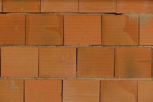 Brick wall displaying textured surface and warm hues, perfect for construction or design inspiration photo